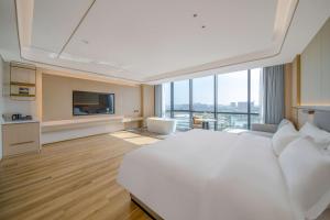 ShundeBodun International Apartment Foshan Shunde Fengjian Water Village Branch的卧室里有一张白色的大床和一台电视