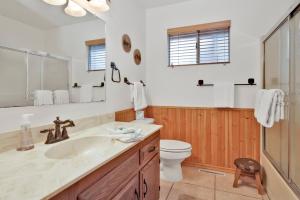 een badkamer met een wastafel, een toilet en een spiegel bij Casa bosque #2176 in Big Bear Lake +12 foto's