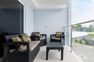 a living room with chairs and a table on a balcony at Viva Jaco II in Jacó