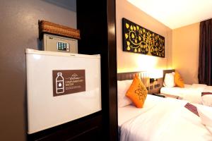 Una habitación de hotel con una cama y un cartel en la pared. en Baan Sukhumvit Soi 20, en Bangkok