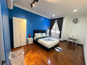 a bedroom with a bed and a blue wall at Melon Resort in Jelutong