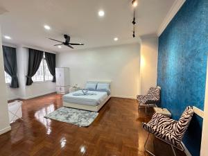 a room with a bed and two zebra chairs at Melon Resort in Jelutong
