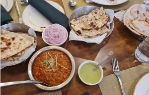a table with bowls of food on a table at Hotel Garden Inn Kochi in Cochin
