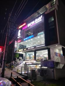 a building with a sign on it at night at Queens Suite Rooms in Channapatna