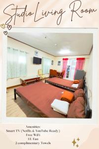 Una habitación con dos camas y una sala de estar. en Lakbay Philippines, en Baguio