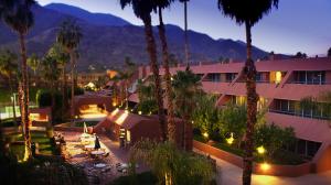 a hotel with palm trees in front of a building at Marquis Villas Resort in Palm Springs