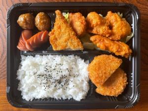 a black plastic container filled with rice and chicken nuggets at Hotel Nissin Kaikan - Vacation STAY 02353v in Shiso