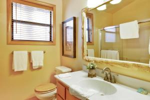 a bathroom with a sink and a toilet and a mirror at Knotty and nice #177 in Big Bear Lake +17 photos