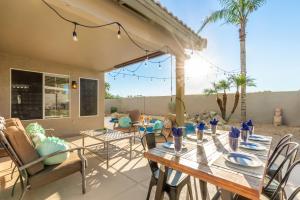 a patio with a wooden table and chairs at 136th Surprise in Surprise