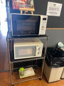 a microwave sitting on a cart with a microwave at Hotel Nissin Kaikan - Vacation STAY 02361v in Shiso +7 photos