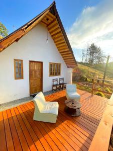 モンテ・ヴェルデにあるChalé em Monte Verde com Lareira e vista das montanhasの木製デッキ(椅子付)
