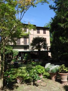 Un bâtiment avec beaucoup de plantes devant lui dans l'établissement Hotel Moderno, à Sienne
