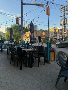 a woman sitting at an outdoor tables and chairs at Private Balcony Studio Apartment for 5 People at Queen Street Downtown in Toronto +5 photos