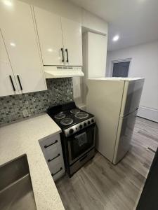 a kitchen with a stove and a refrigerator at Private Balcony Studio Apartment for 5 People at Queen Street Downtown in Toronto