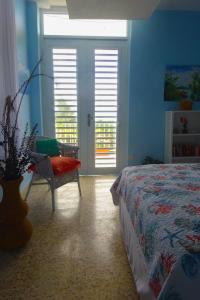 a bedroom with a bed and a chair and a window at A Seascape Guest Room in Fajardo