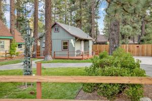 ein kleines Haus im Wald mit einem Holzzaun in der Unterkunft Beary cozy cabin #2315 in Big Bear Lake