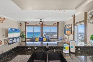 eine Küche mit Spüle und ein Wohnzimmer in der Unterkunft End Unit - Directly On The Gulf! Sleeps 6! Italian Luxury Furnishings! in Panama City Beach