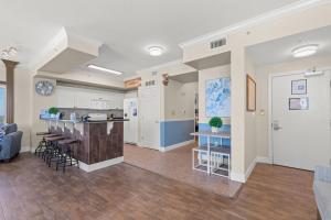 eine offene Küche und ein Wohnzimmer mit einer Theke und Stühlen in der Unterkunft End Unit - Directly On The Gulf! Sleeps 6! Italian Luxury Furnishings! in Panama City Beach