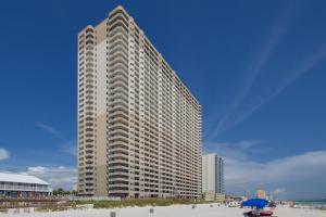 ein hohes Gebäude am Strand mit Strandgmaxwell in der Unterkunft End Unit - Directly On The Gulf! Sleeps 6! Italian Luxury Furnishings! in Panama City Beach
