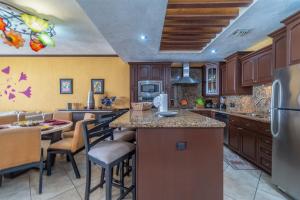 a kitchen with wooden cabinets and a kitchen island with bar stools at Viva Beach Life Comfortable Oceanfront in Puerto Peñasco