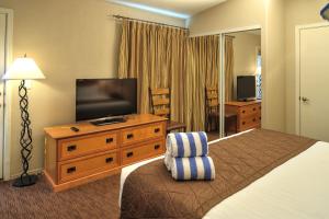 a hotel room with a bed and a flat screen tv at PVC at The Roundhouse Resort in Pinetop-Lakeside