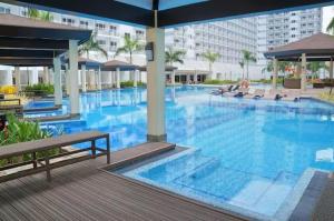 a large swimming pool with blue water in a building at Your Home Away from Home-Shell in Sampong