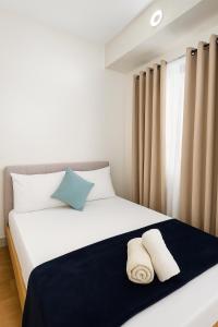 a bedroom with a bed with two towels on it at Camella Northpoint in Davao City +23 photos