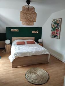 a bedroom with a bed with a green headboard at Appartement spacieux en centre ville de Besse in Besse-et-Saint-Anastaise