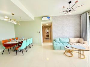 een woonkamer met een blauwe bank en een tafel bij Dear You, Apartment! Saigon - Rivergate Building in Ho Chi Minh-stad