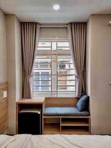 a window seat in a bedroom with a bed at BLUE SÀI GÒN Homestay in Ho Chi Minh City
