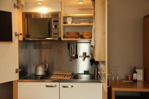 a kitchen with a sink and a microwave at Boardhousing in Leuven