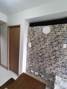 a room with a brick wall with a clock on it at Aldo mall of Asia condotel in Manila