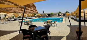 a pool with tables and chairs in front of a building at The bubble camp in Aqaba