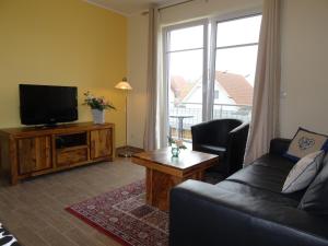ein Wohnzimmer mit einem Sofa und einem TV in der Unterkunft Villa Rerik in Rerik
