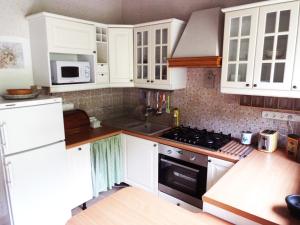 a kitchen with white cabinets and a stove top oven at Villa Panorama Artist in Dömös