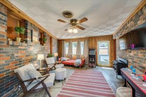 a living room with a ceiling fan and a brick wall at Eagle Rock Base Camp in Boise