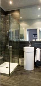 a bathroom with a toilet and a glass shower at Century Hotel in Parma