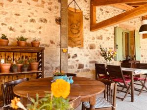 a dining room with a wooden table and chairs at chambres d'hôtes Domaine les Grands Pérons in Hérisson