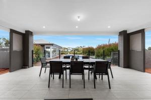 a dining room with a table and chairs on a patio at 10BR great ocean farmstay for 20 people in Leopold