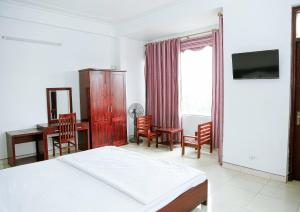 a bedroom with a bed and a desk and a table at Trường Yến Hotel Ninh Bình in Ninh Binh