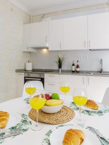 a table with two glasses of wine and a bowl of fruit at Stay Belonio El Palo Beach in Málaga