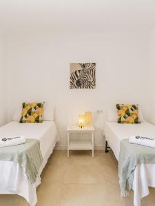 two beds in a room with a table at Stay Belonio El Palo Beach in Málaga +11 photos