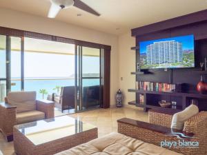 un salon avec un canapé et une télévision dans l'établissement Playa Blanca Premier Unit 503, à Isla Venado