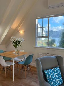 ダニーデンにあるSunny Waterfront Apartmentのテーブルと椅子と窓のあるダイニングルーム