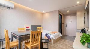 a bedroom with a bed and a table and a dining room at Shell Hotel Wuxi Huishan District Chang'an Town in Wuxi
