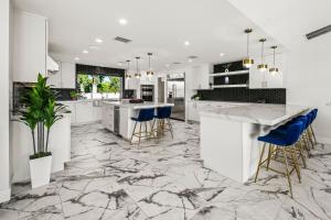 a kitchen with white cabinets and blue bar stools at Lazy River Oasis in Bermuda Dunes
