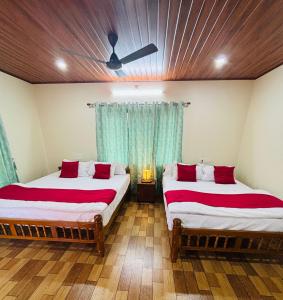 Un dormitorio con dos camas y un techo. en River Raga Nature Resort, en Kārkāl