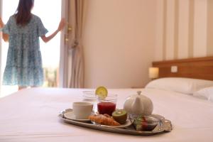un vassoio di cibo su un letto con un piatto di cibo di Hotel Castel Miramonti a Selva di Fasano