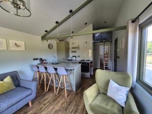 a kitchen and living room with a couch and a table at Birch Banc Retreats - Bedw in Llanidloes +12 photos