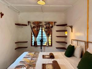 una camera con letto, finestra e scaffali di Hera Hostel Diani a Diani Beach